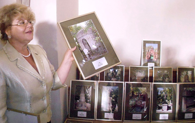 Wiktoria Radik demonstruje na wystawie fotografię uporządkowanego grobu rodziny Góreckich na Cmentarzu Bajkowa